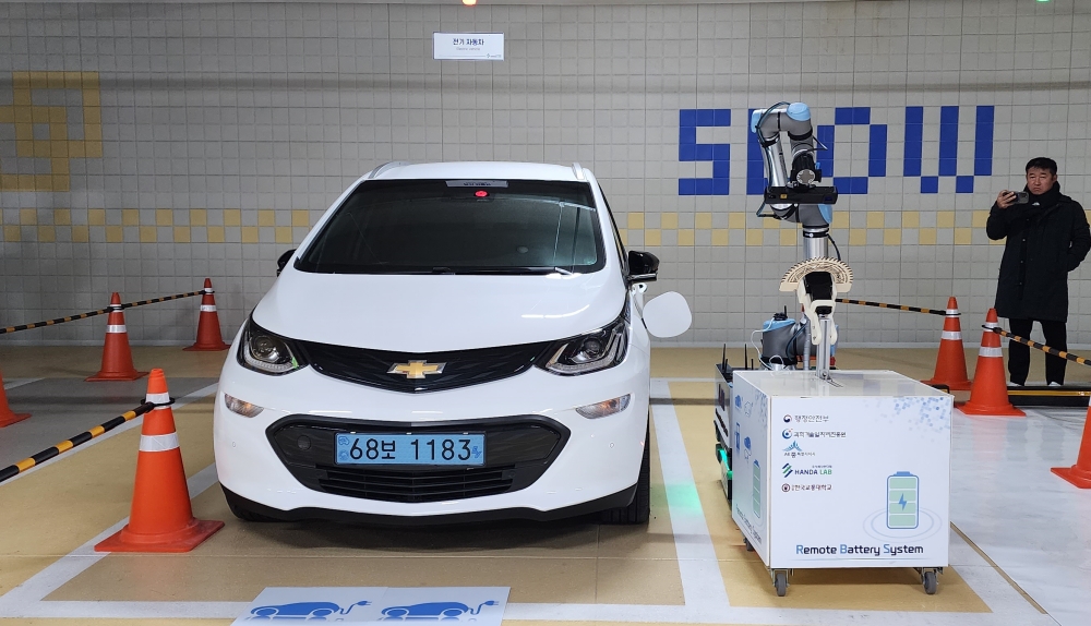 자율주행로봇이 휴대용 충전기를 운반해 차량이 주차된 곳으로 찾아가 전기차 충전을 하고 있다.