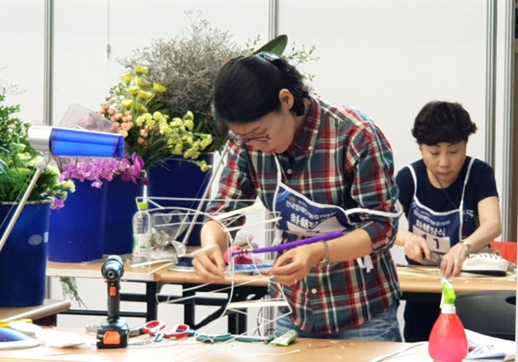 전국장애인기능경기대회 화훼장식종목에서 김미정씨가 심혈을 기울여 작품을 만들고 있다.